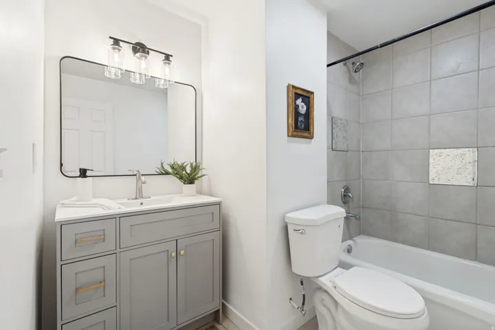 Bathroom featuring a modern vanity with a rectangular sink, satin nickel faucet, and a large framed mirror