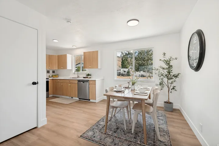 Open-concept kitchen and dining area featuring wood-finish flooring, white walls, and recessed lighting