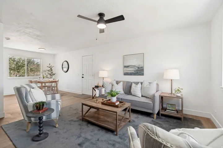 Bright living area featuring wood-finish flooring and a contemporary ceiling fan