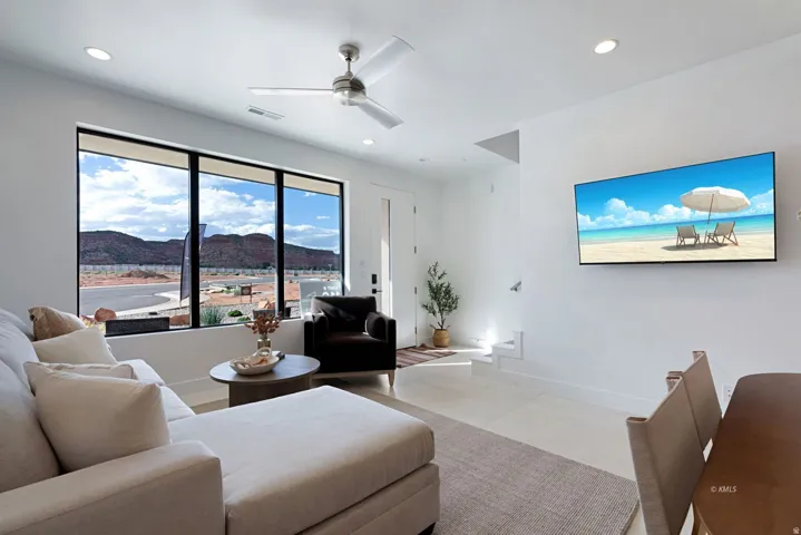 Spacious living area featuring large windows with mountain scenery, recessed lighting, and a ceiling fan