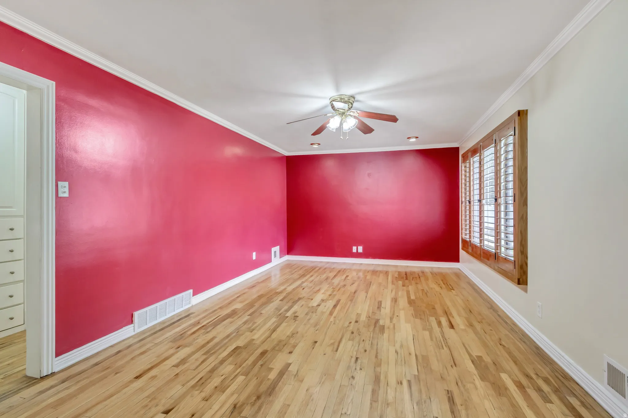 Spacious interior room featuring wood-finish flooring, crown molding, and recessed lighting