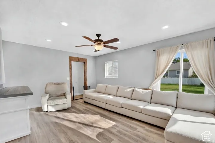 Spacious living area featuring wood-finish flooring, recessed lighting, and a ceiling fan