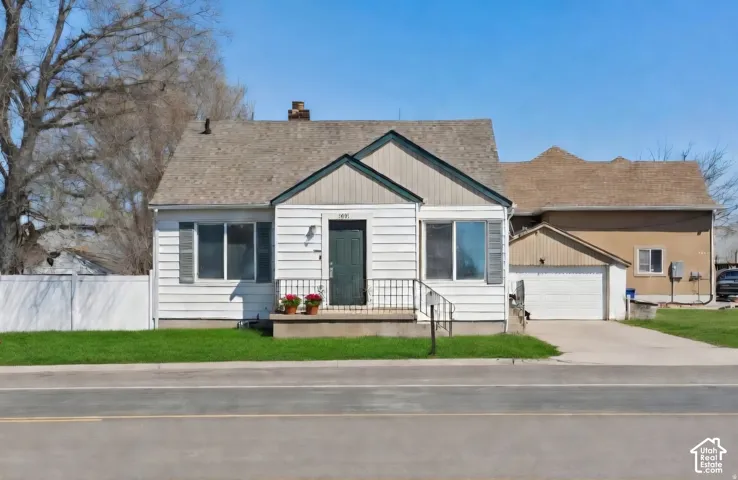White horizontal siding exterior with dark green trim and a coordinating front door