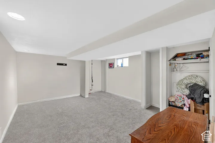 Carpeted room with recessed lighting and a window