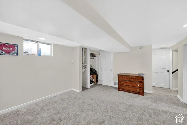 Carpeted room featuring light-colored walls and white trim