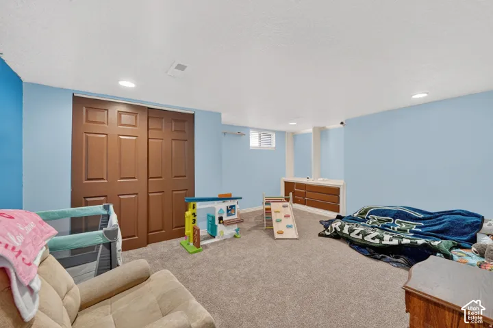 Spacious room with light blue walls and neutral carpet flooring
