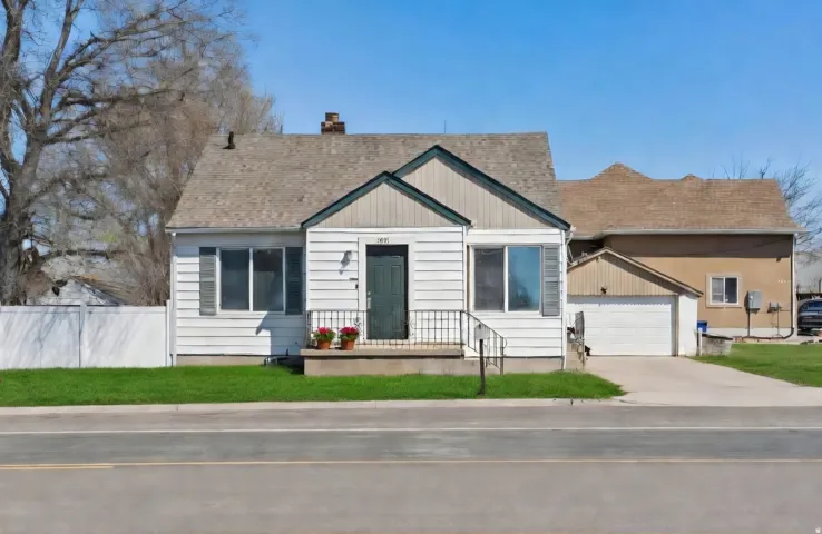 White horizontal siding exterior with dark green trim and a coordinating front door