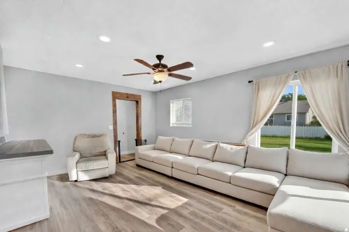Spacious living area featuring wood-finish flooring, recessed lighting, and a ceiling fan