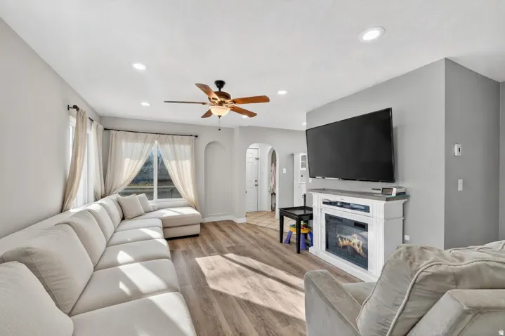 Living area featuring wood-finish flooring, recessed lighting, and a ceiling fan