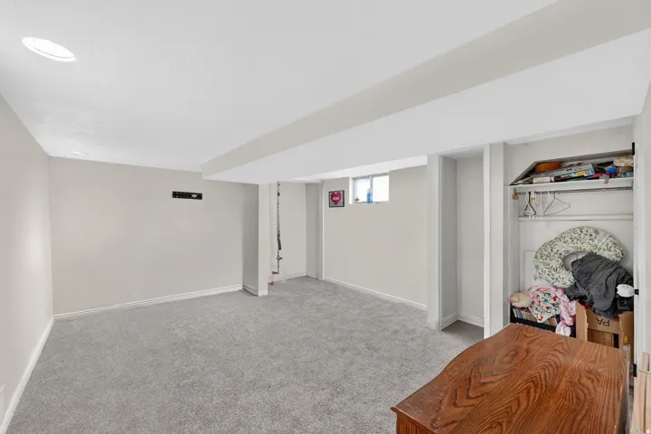 Carpeted room with recessed lighting and a window