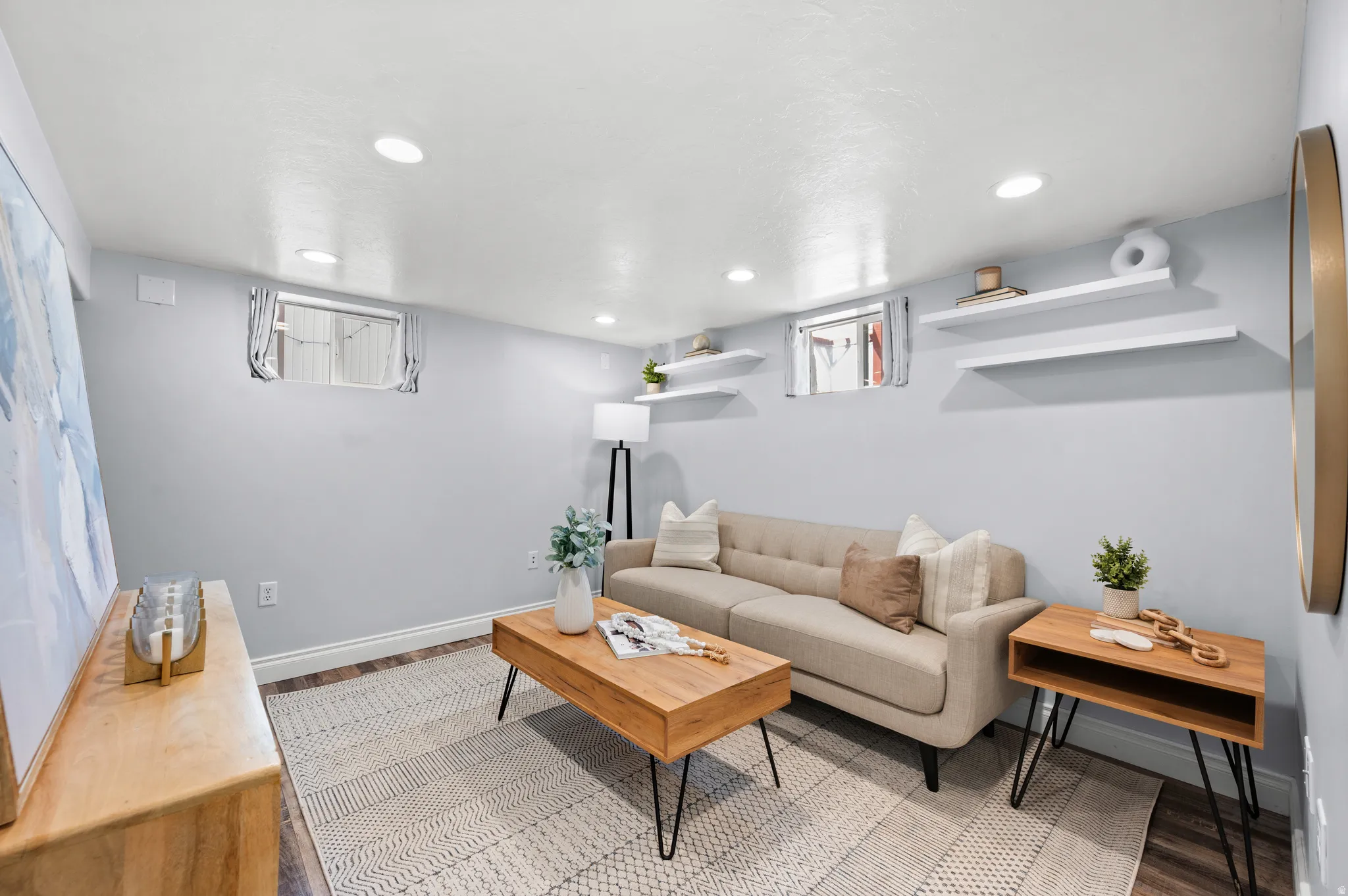 Recessed lighting illuminates this room featuring light-toned walls and wood-finish flooring