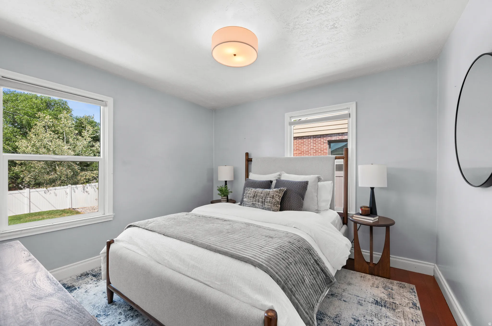 Light-filled room featuring wood-finish flooring, light blue wall paint, and white trim