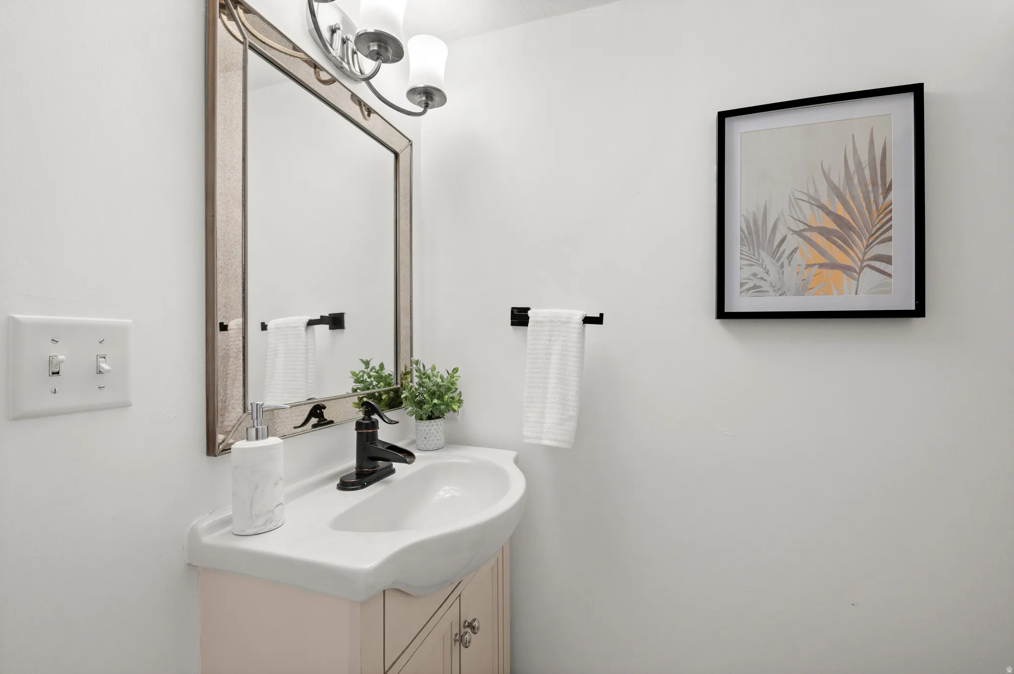 Vanity with an integrated white sink, matte black faucet, and light-toned cabinetry