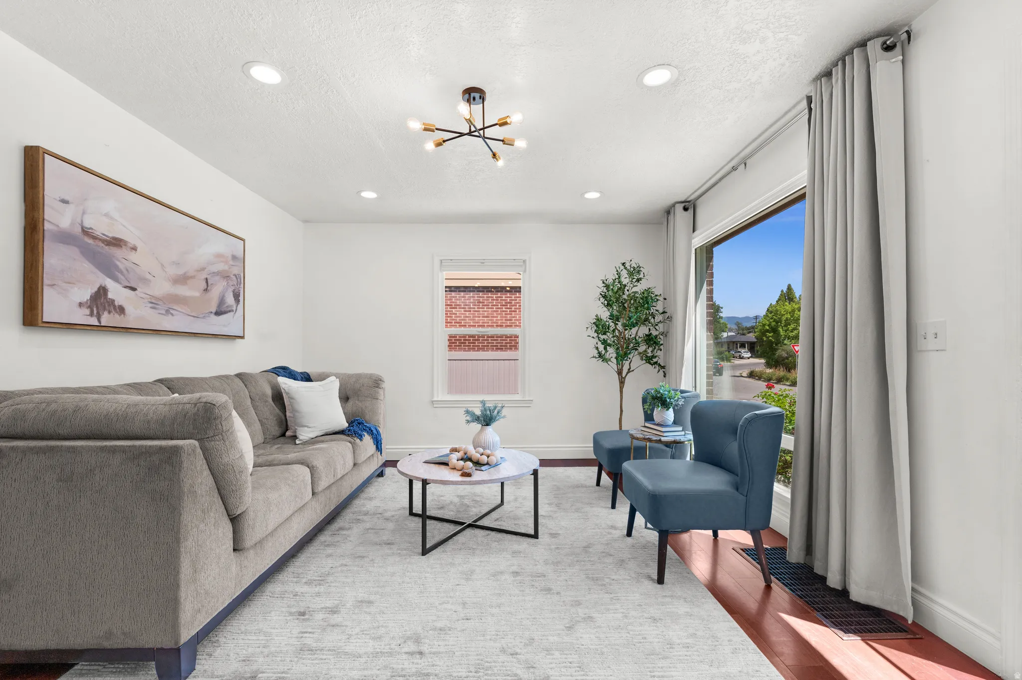 Living area featuring wood-finish flooring, recessed lighting, and a modern ceiling fixture
