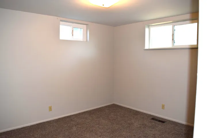 Neutral-toned walls complement the textured carpet flooring