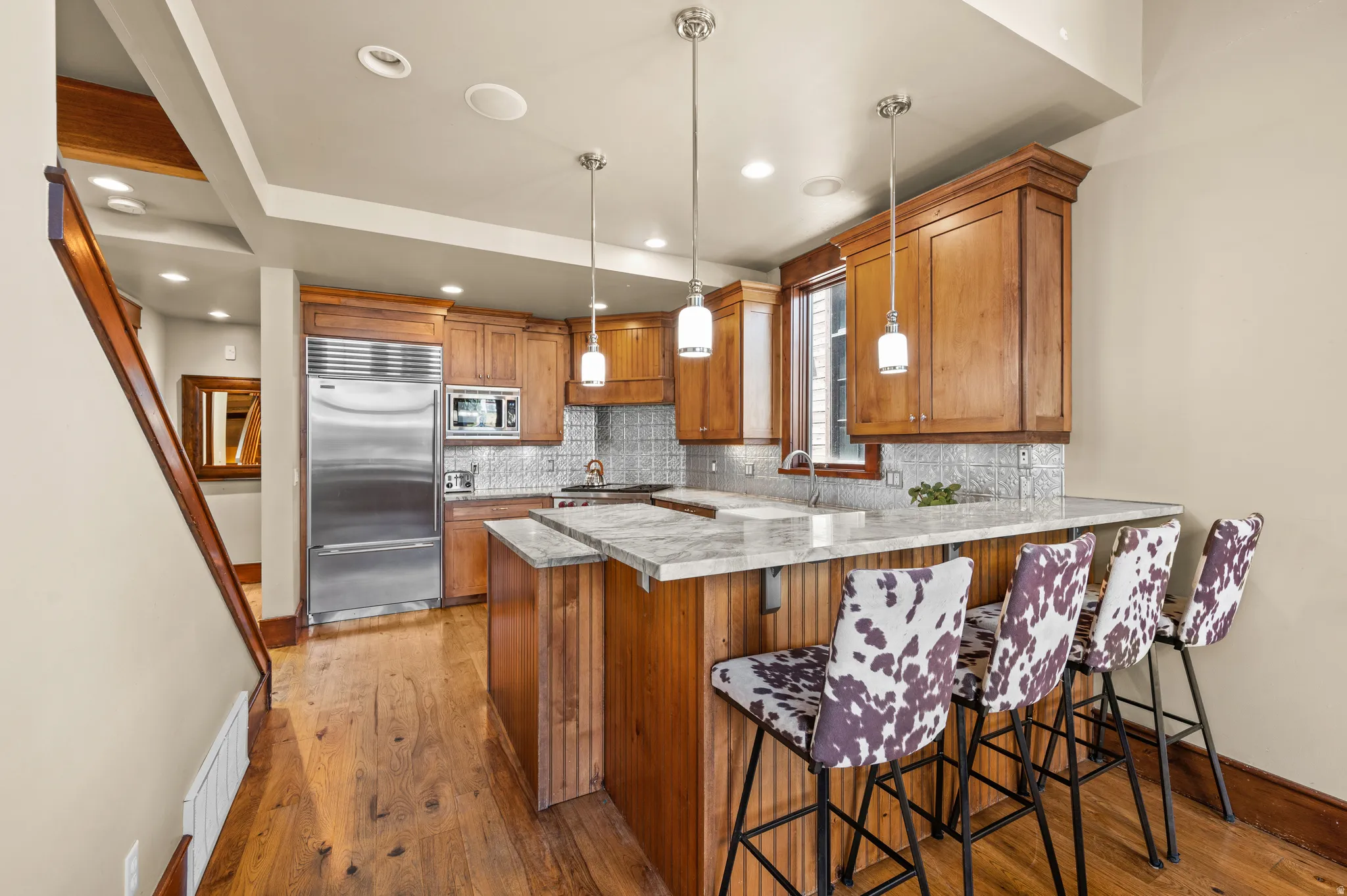 Full kitchen featuring wood cabinetry, stainless steel appliances, and a mosaic tile backsplash