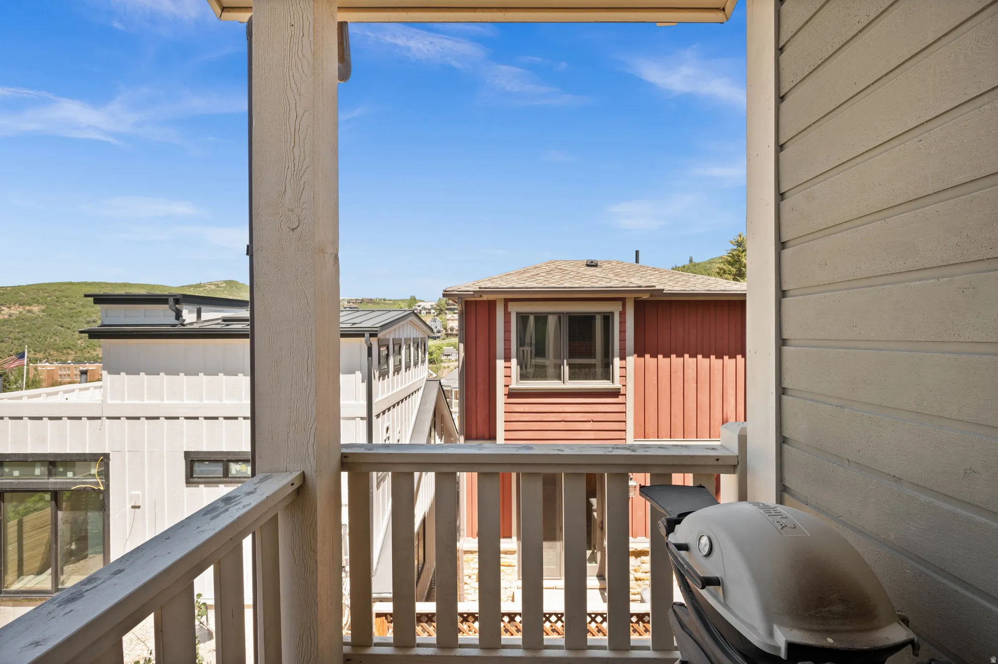 Balcony featuring a light-toned wooden railing and a structural support post