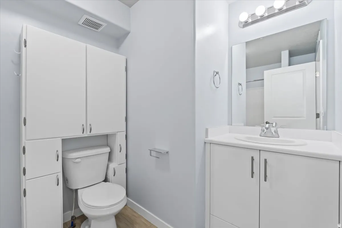 Bathroom featuring a white vanity with integrated sink, chrome faucet, and rectangular mirror