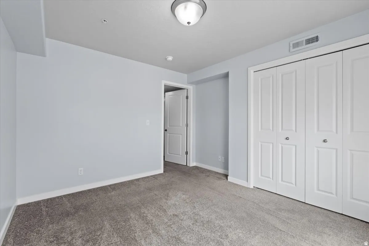 Room with grey carpeting, light blue walls, and white trim