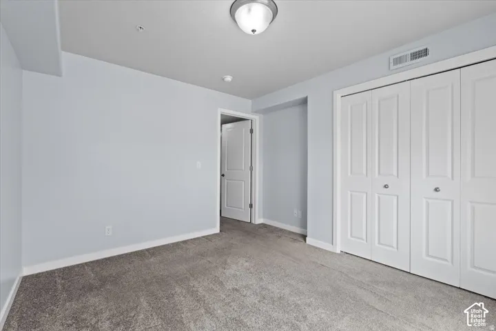 Room with grey carpeting, light blue walls, and white trim