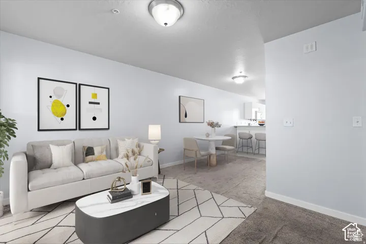 Open-concept living area featuring light-colored walls and overhead lighting