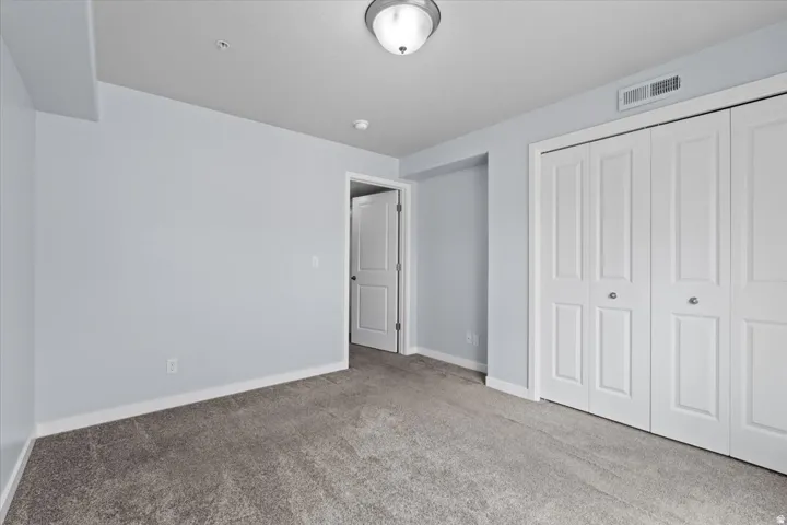 Room with grey carpeting, light blue walls, and white trim