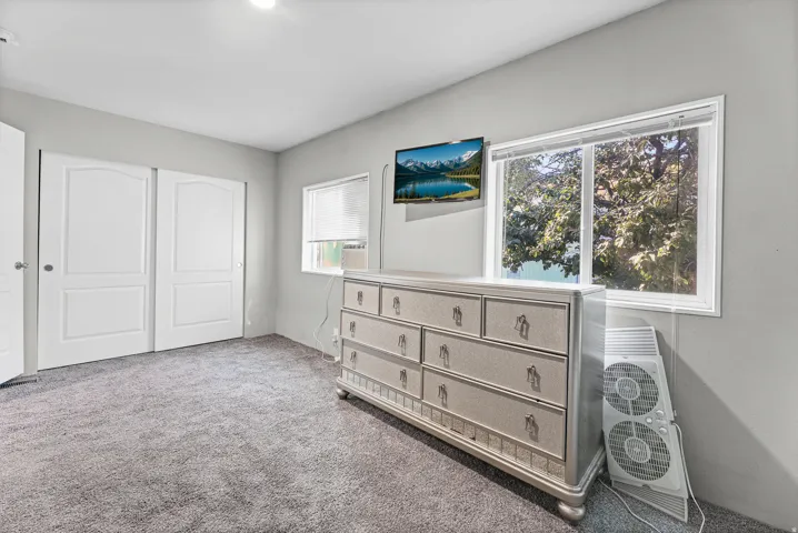 Spacious room featuring gray wall paint and matching gray carpet flooring