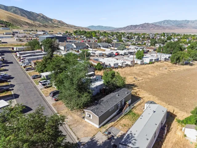 Residential community featuring multiple manufactured homes and paved roadways, set against a backdrop of distant mountains