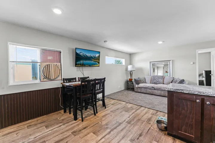 Open-concept living area featuring wood-finish flooring, recessed lighting, and a neutral wall color