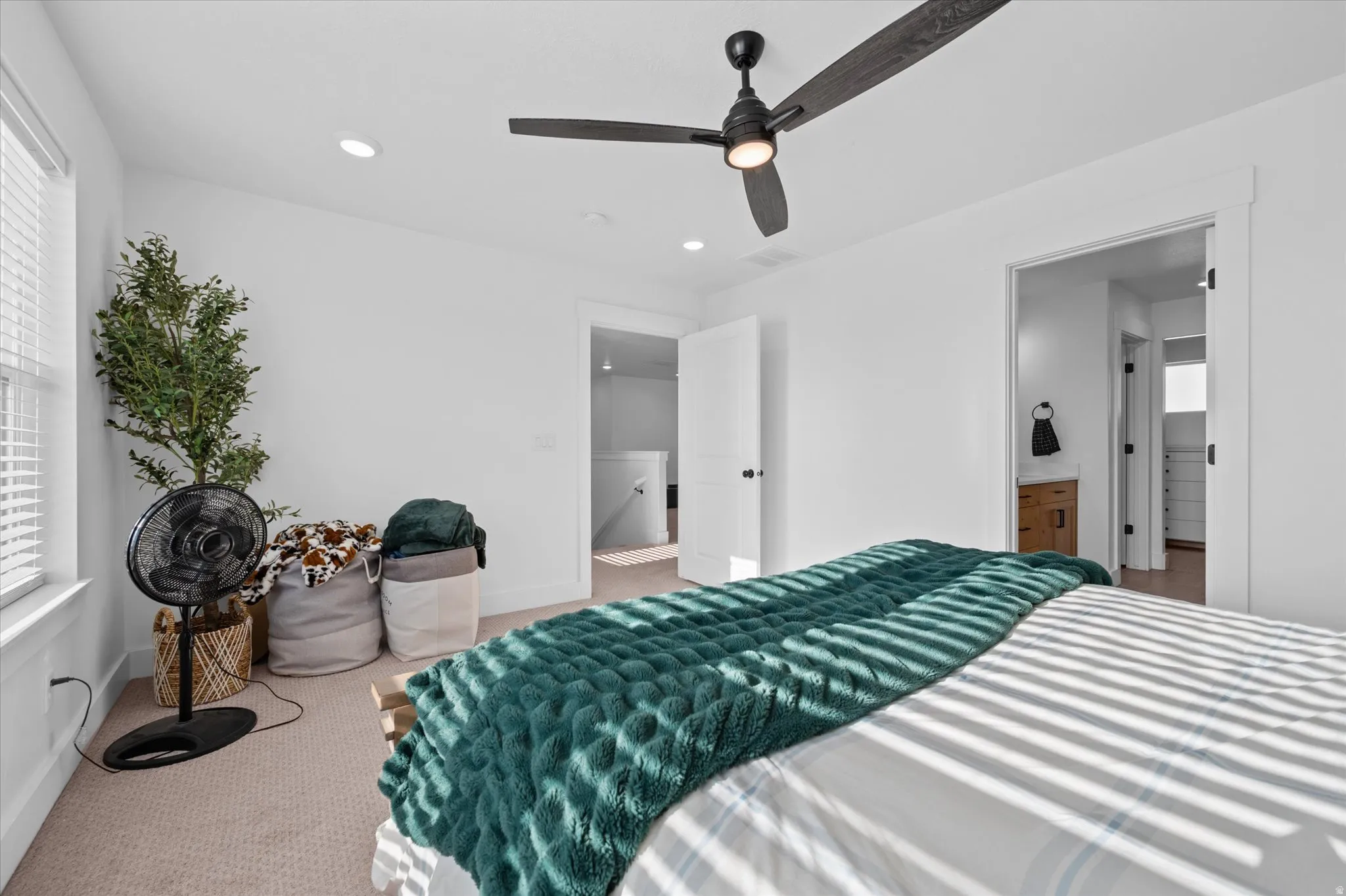 Recessed ceiling lighting, ceiling fan, white interior doors, and carpeted flooring