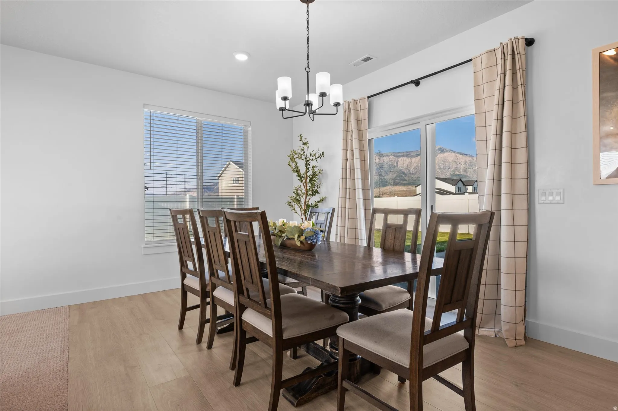Recessed lighting, contemporary chandelier, wood-finish flooring, sliding glass door, and mountain scenery