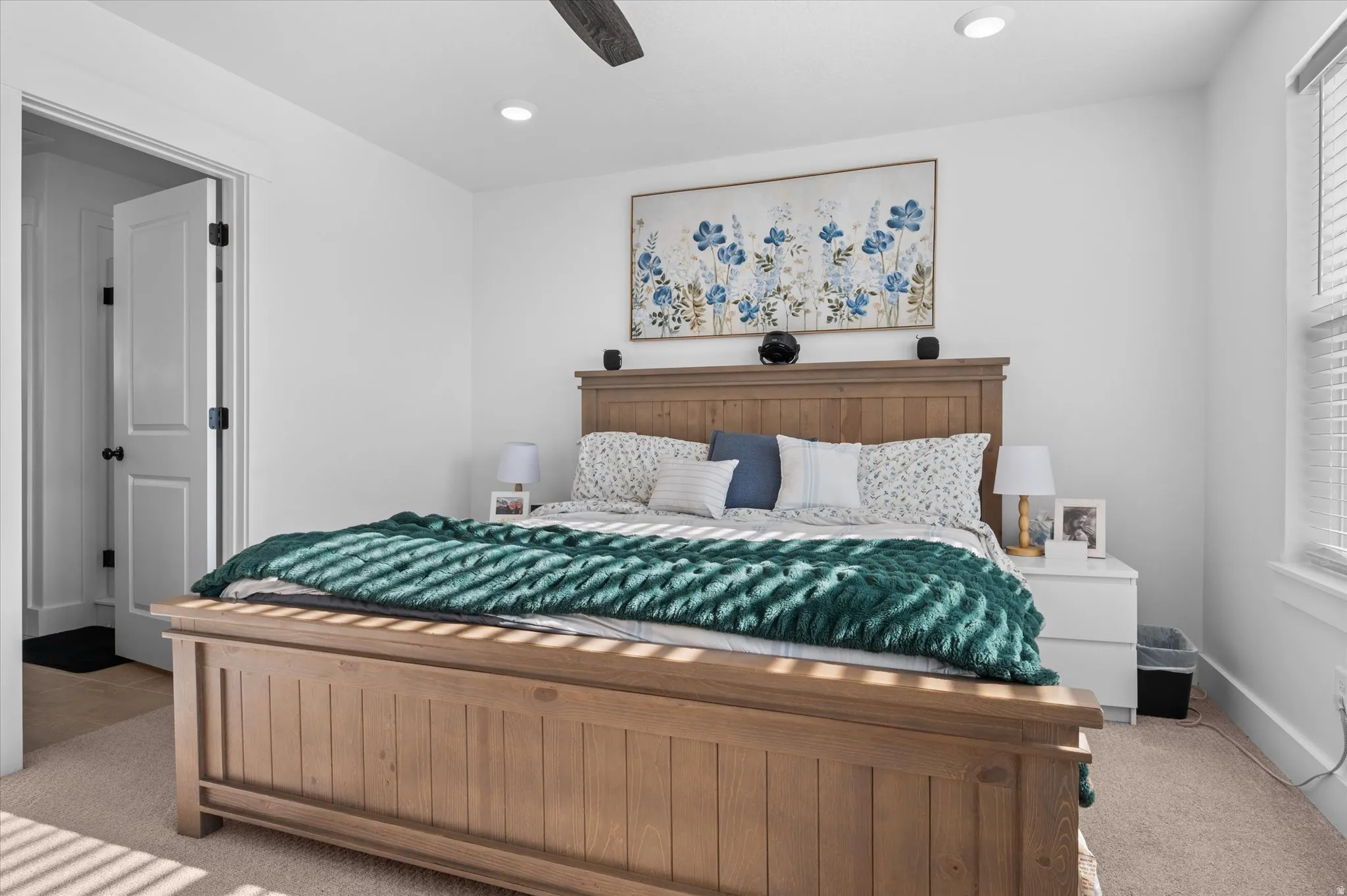 Recessed ceiling lighting, a dark wood-finish ceiling fan, an interior door with dark hardware, and a window with blinds