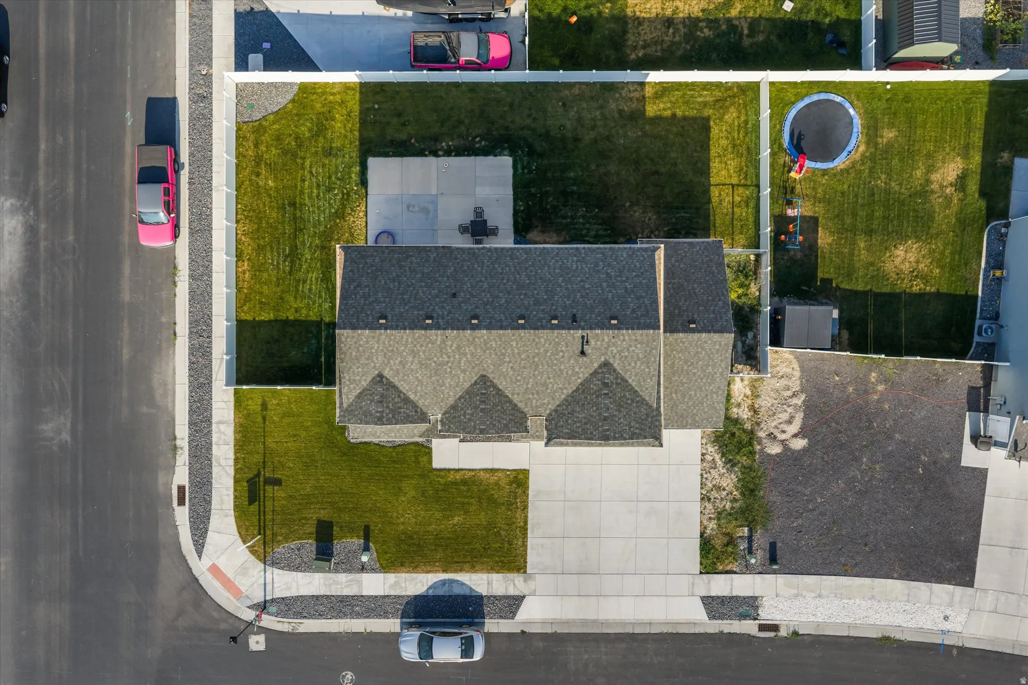 Asphalt shingle roofing over a multi-level structure with a concrete driveway and sidewalk