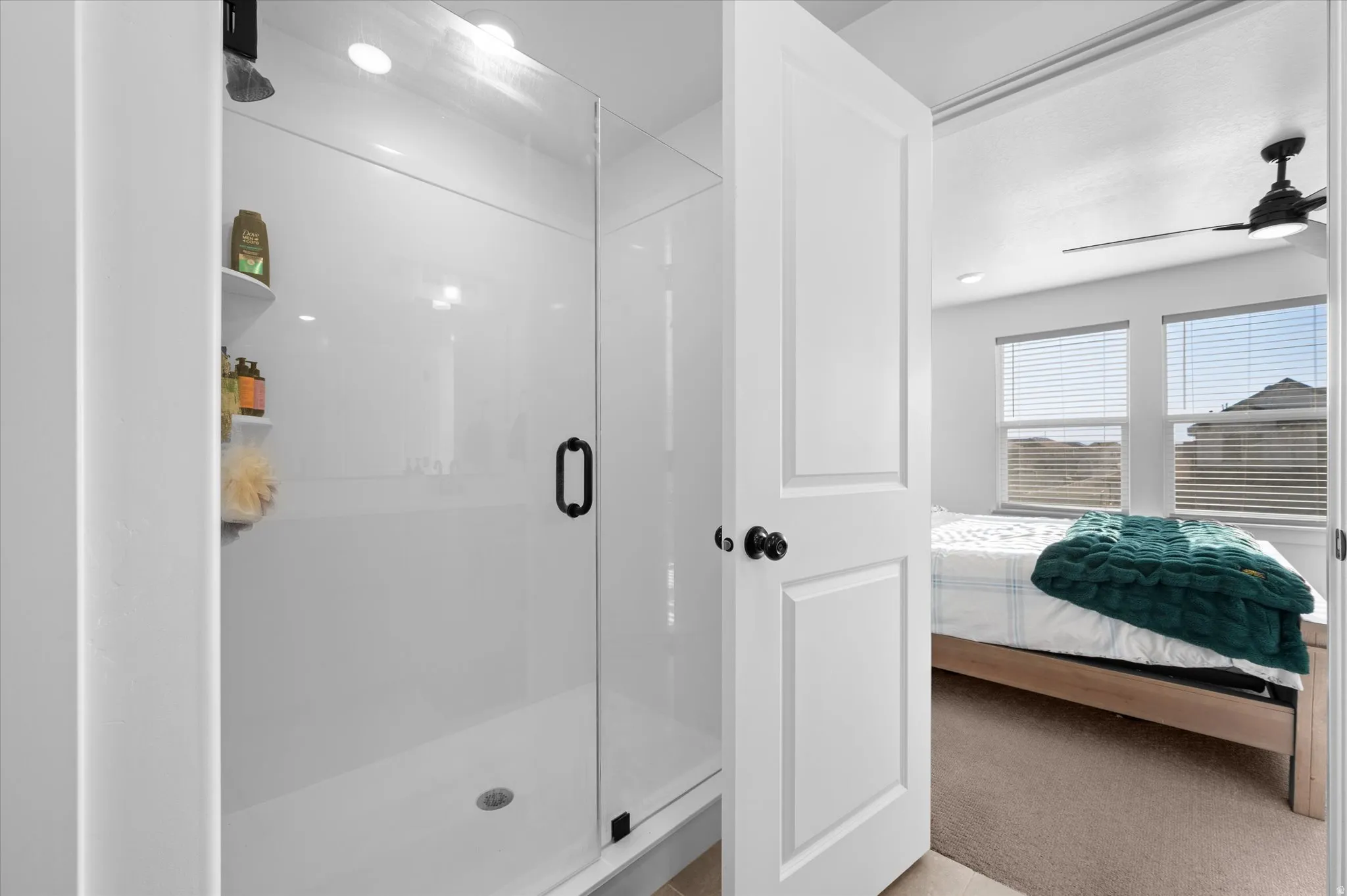 Walk-in shower with clear glass enclosure and black hardware