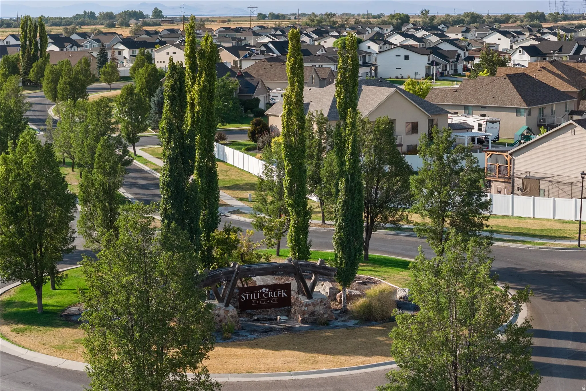 Community entrance with stone monument and overhead wooden archway