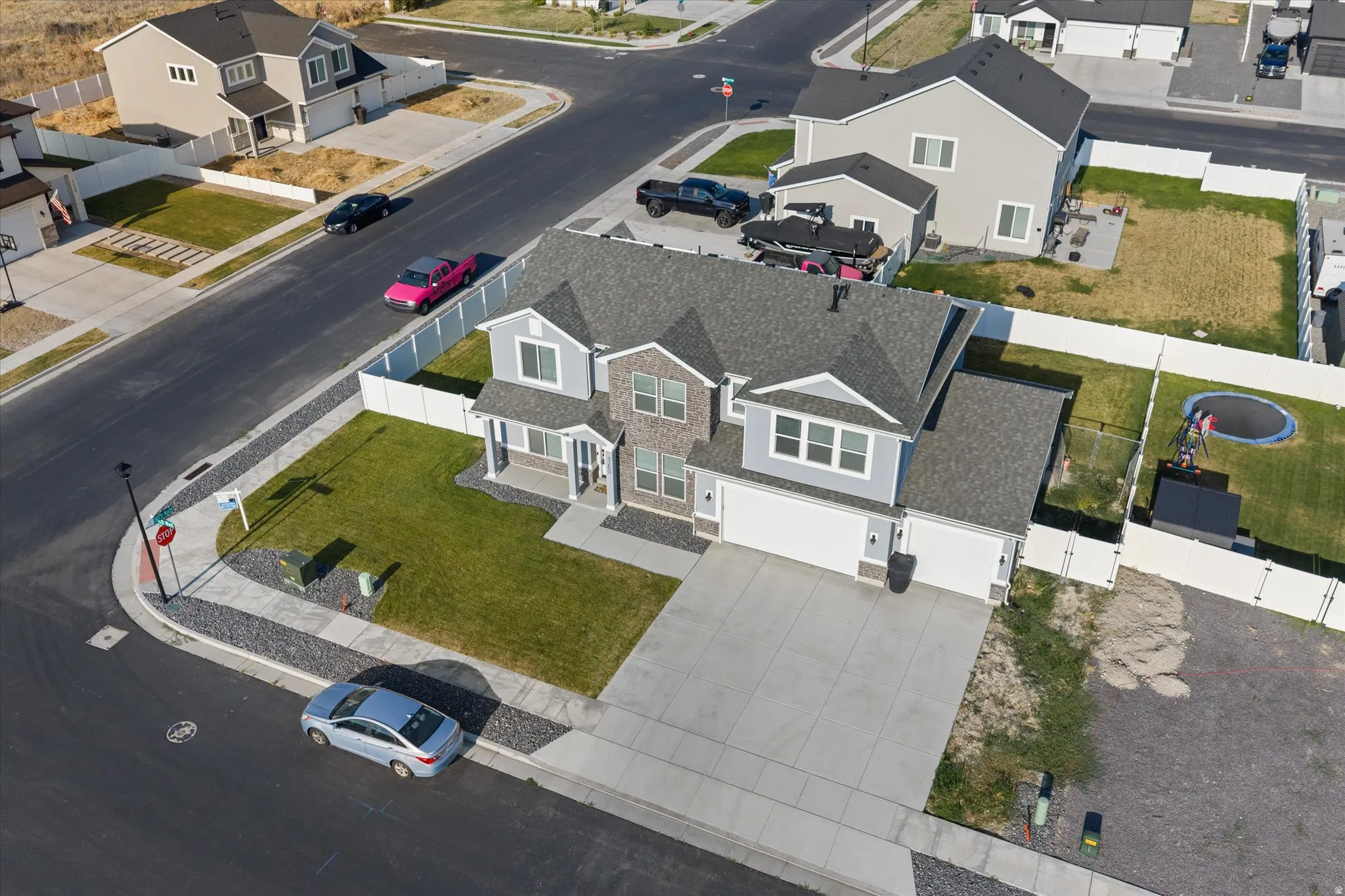 Two-story residence with a gray shingle roof, light blue siding, and brick accents