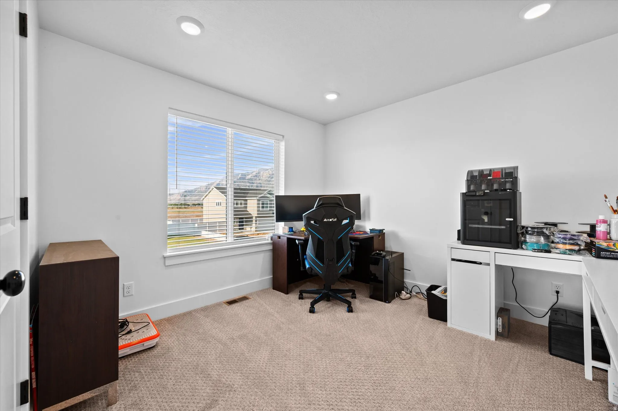 Recessed lighting, large window with natural light, neutral wall colors, and textured carpeting