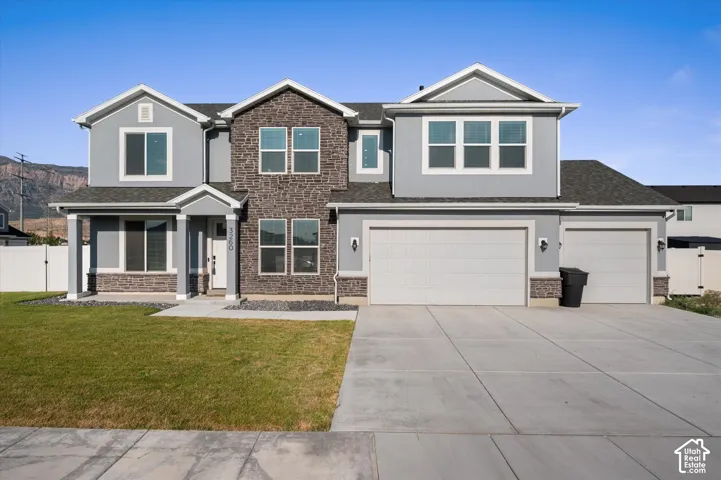 Stucco and stone exterior with gabled roof lines, beautiful windows, an attached three-car garage.