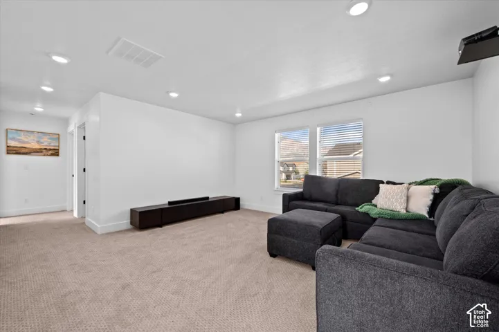 Loft Area featuring neutral carpeting, two windows with blinds, and white walls