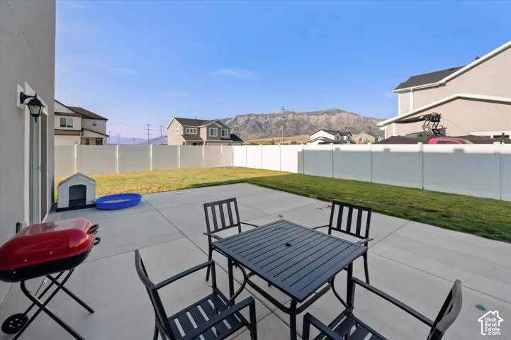 Expansive concrete patio with a full white privacy fence surrounding a grass lawn