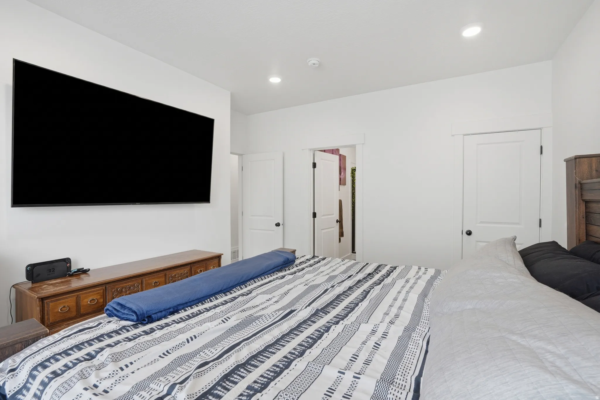Spacious room featuring a wall-mounted display, recessed lighting, and white trim throughout