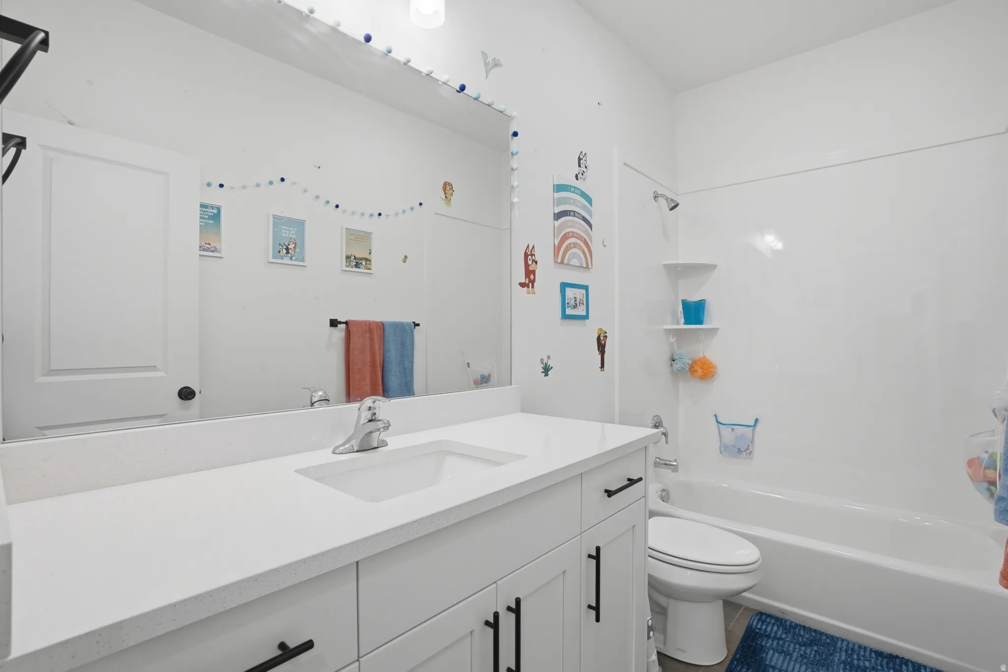White vanity with integrated sink, chrome faucet, and black hardware