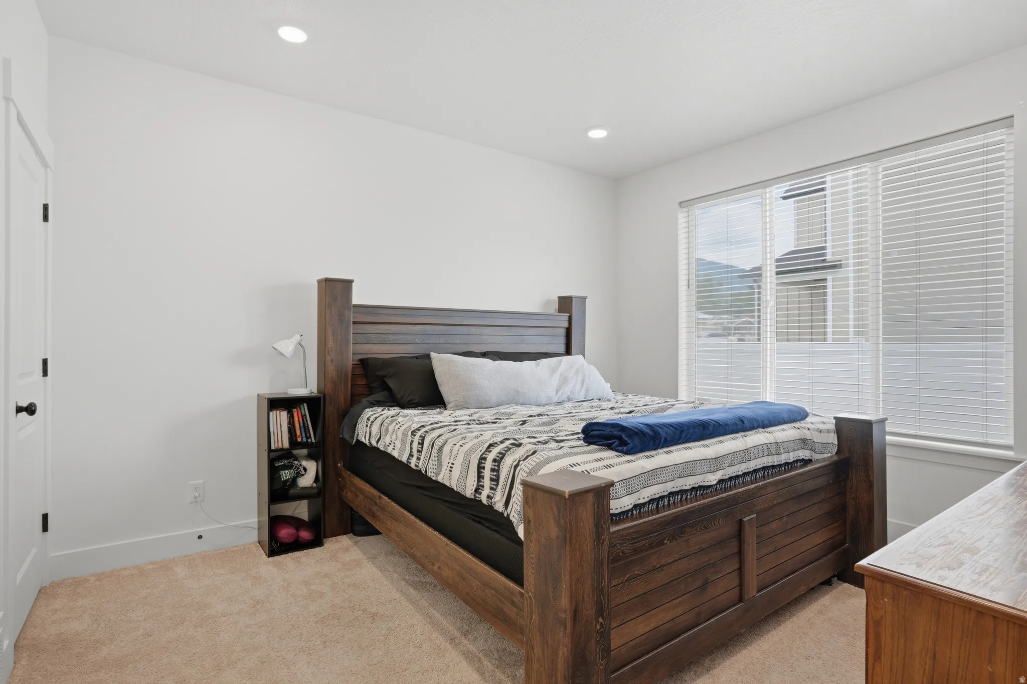 Bedroom featuring neutral wall paint, recessed lighting, a large window with blinds, and light-colored carpet flooring