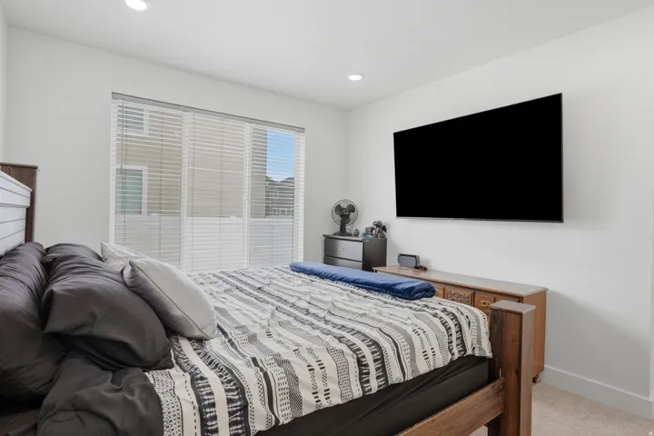 Bright room with neutral wall paint, recessed lighting, a large window with horizontal blinds, and a mounted wall display