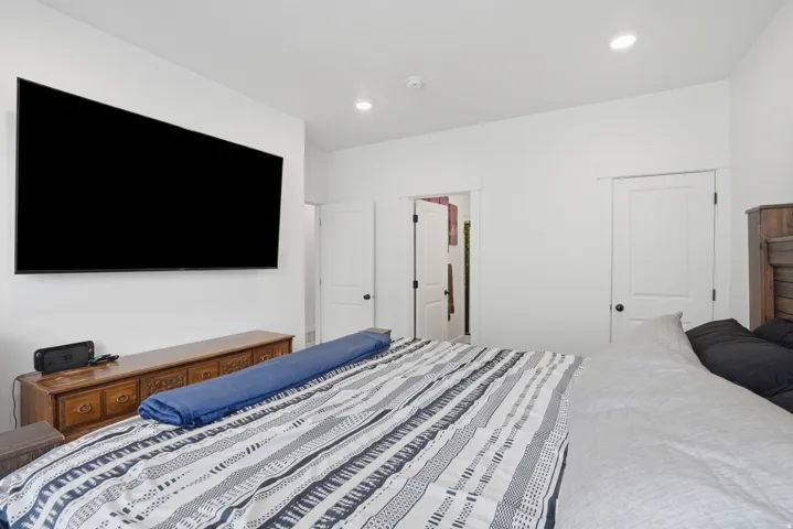 Spacious room featuring a wall-mounted display, recessed lighting, and white trim throughout