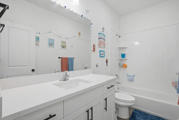 White vanity with integrated sink, chrome faucet, and black hardware