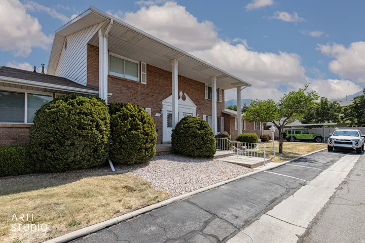 Brick exterior featuring white columns and a covered entry