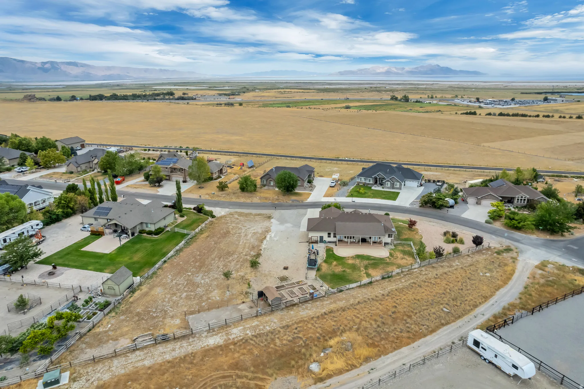 Aerial perspective showcasing a residential neighborhood with distant mountain and open field scenery