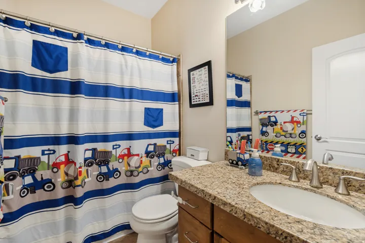 Bathroom featuring a vanity with a granite-style countertop, undermount sink, and brushed nickel fixtures