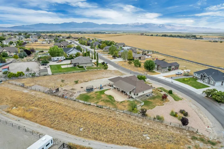 Expansive property featuring a paved driveway, a large rear patio, mature landscaping, and mountain scenery